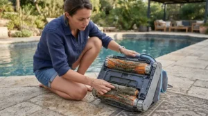 Checking brushes on a robotic pool cleaner for pets with hair in the pool to prevent tangling.